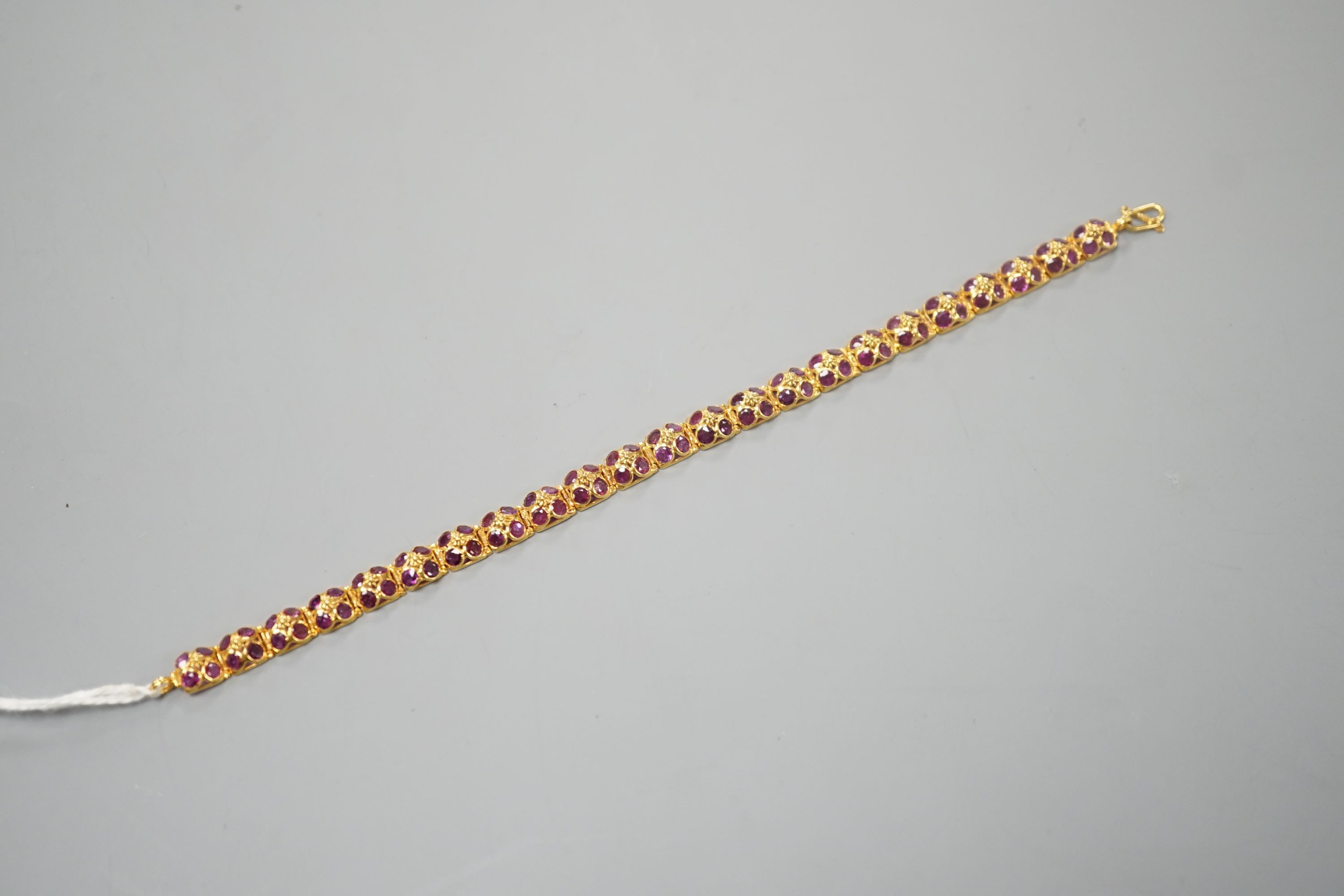 A modern Thai yellow metal and pink gem set cluster bracelet, 17cm, gross weight 8.7 grams.